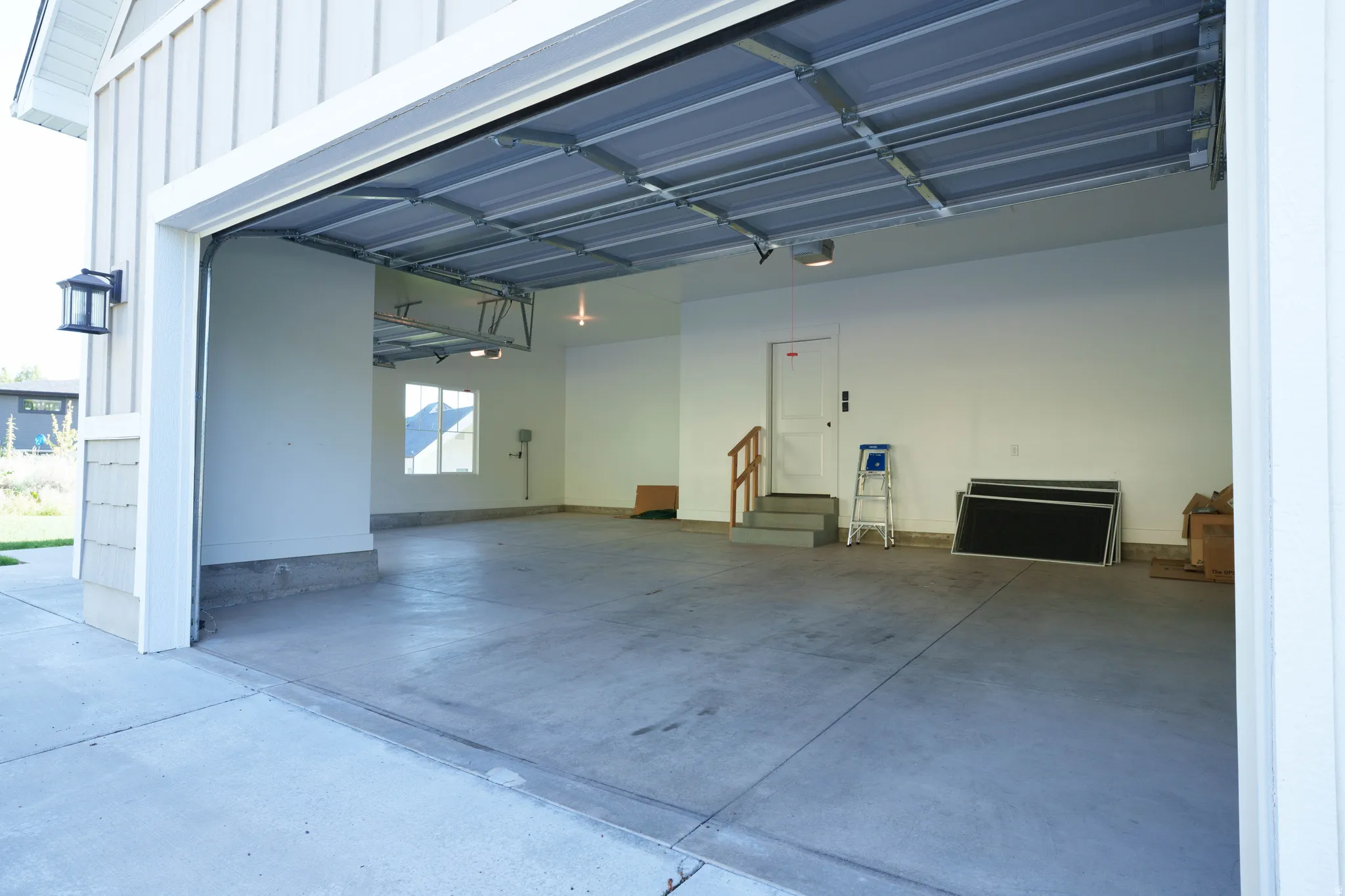 Spacious two-car garage with a concrete floor and white painted walls