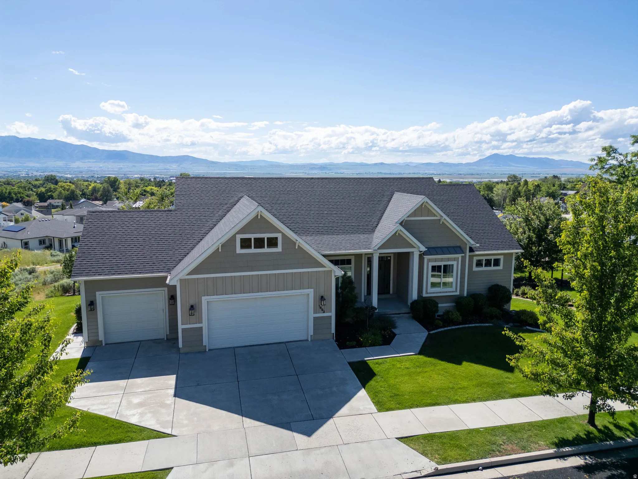 Modern Craftsman-style residence featuring a two-car garage, established front landscaping, and a concrete driveway