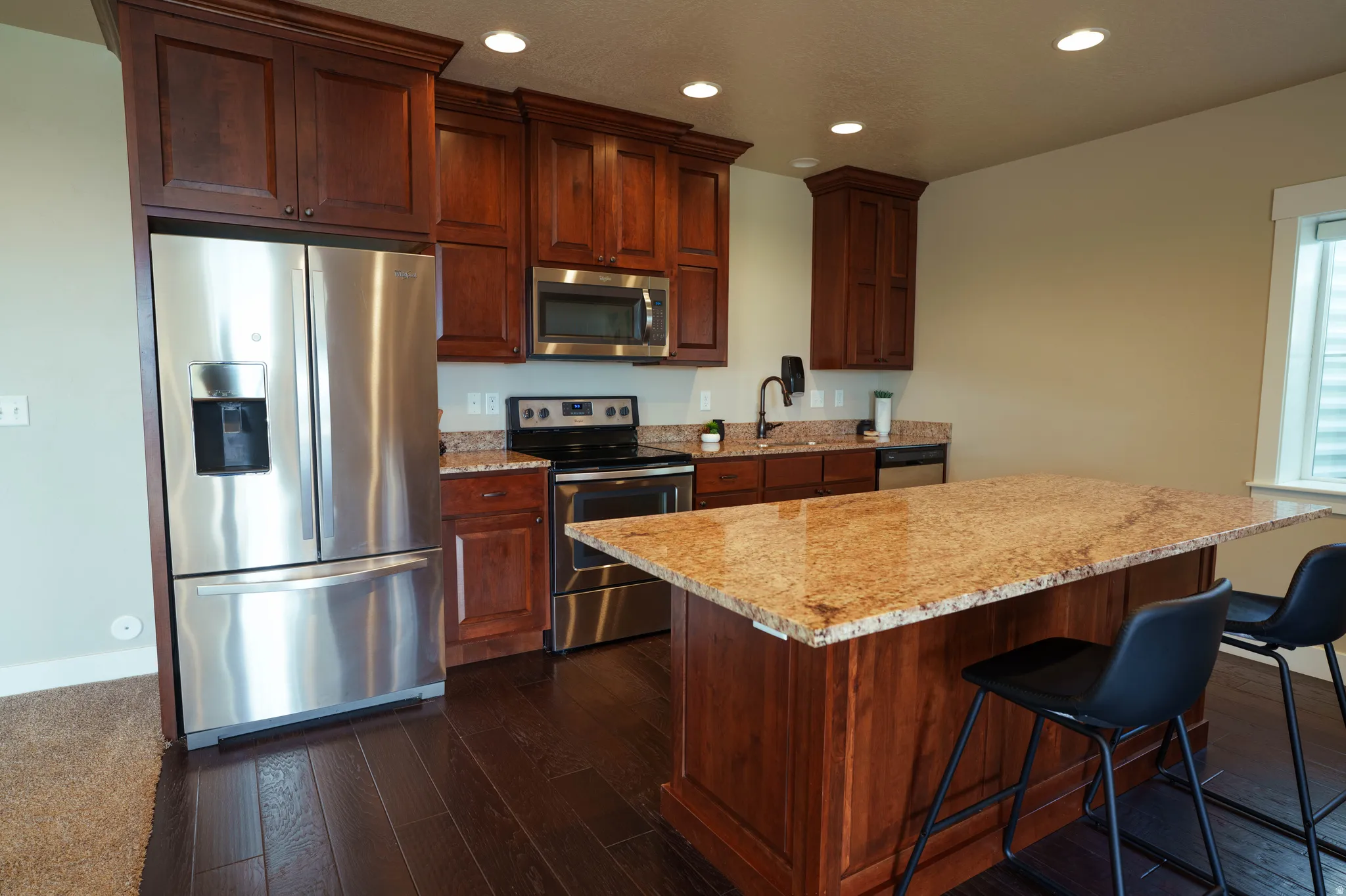 Kitchen featuring dark wood-finish flooring, recessed lighting, and a window with blinds