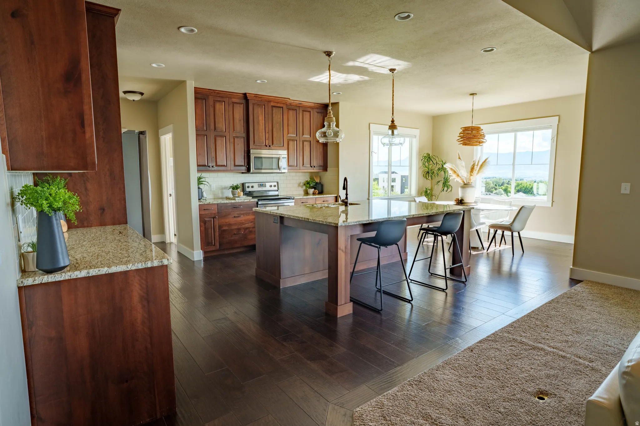 Spacious kitchen featuring rich wood cabinetry, stainless steel appliances, and a large central island with seating