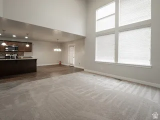 Spacious living area featuring high ceilings and large windows with blinds