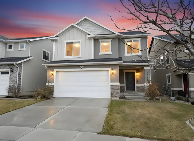 Contemporary two-story exterior featuring a two-car garage, stone accents, and a covered porch entry