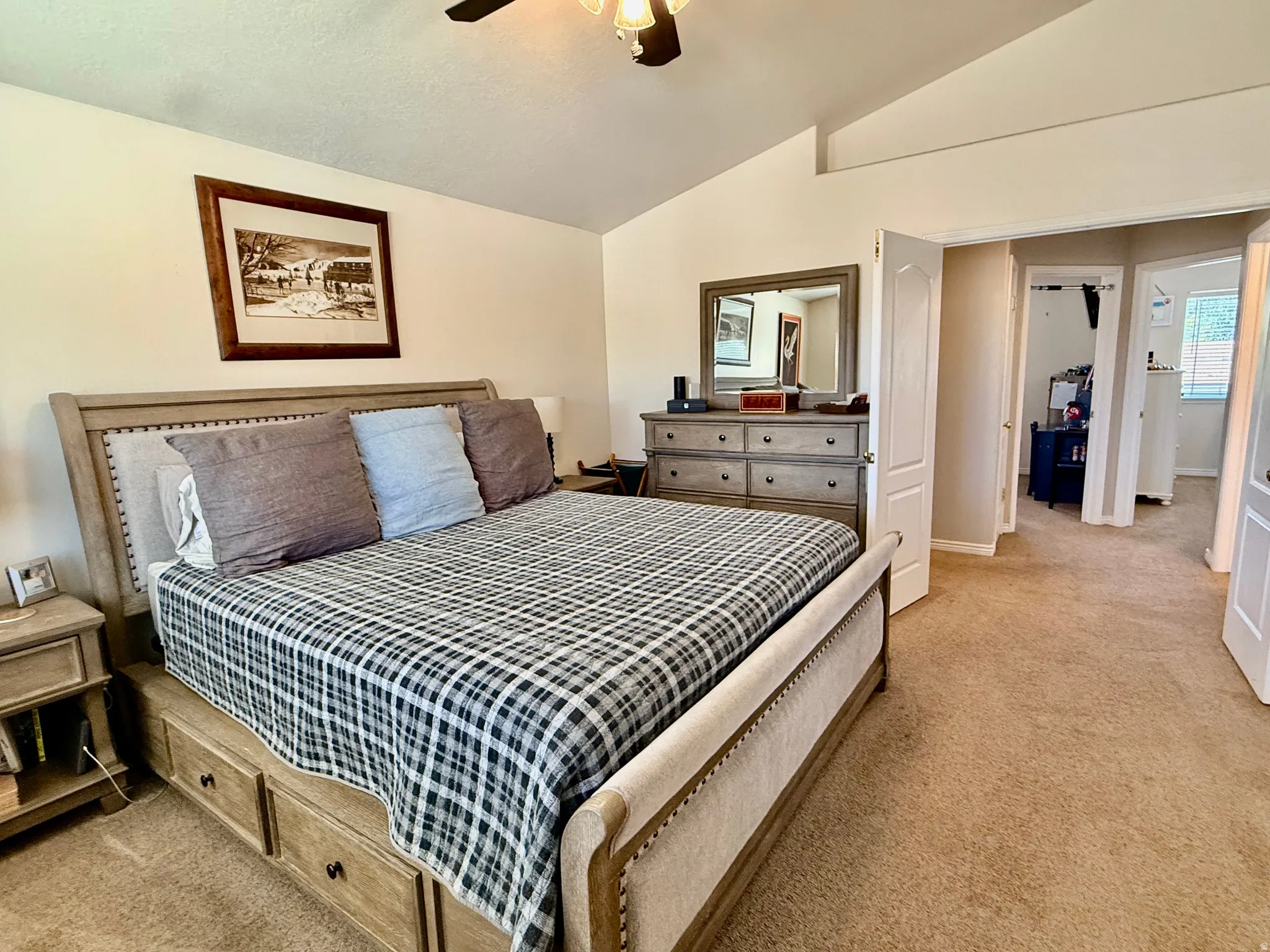 Spacious room featuring vaulted ceilings, light-toned walls, and neutral carpeting