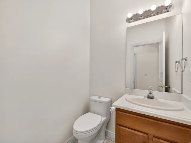 Bathroom vanity featuring a wood-finish cabinet, integrated sink, and chrome faucet