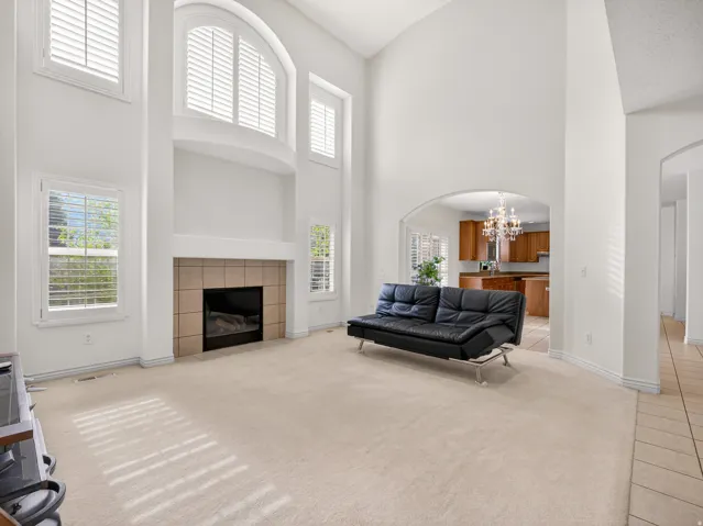 Two-story living area featuring a central fireplace with a tiled surround