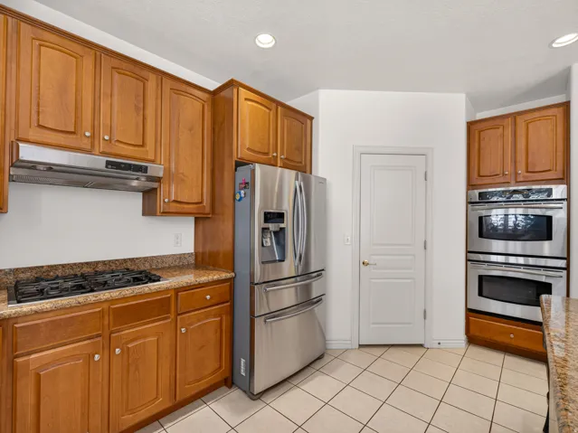 Kitchen featuring wood cabinetry, light-toned countertops, and tile flooring
