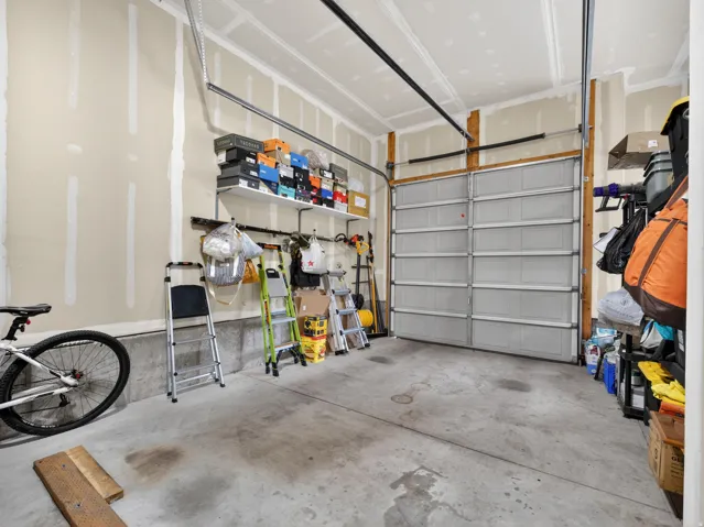 Concrete flooring and unfinished walls with a metal garage door