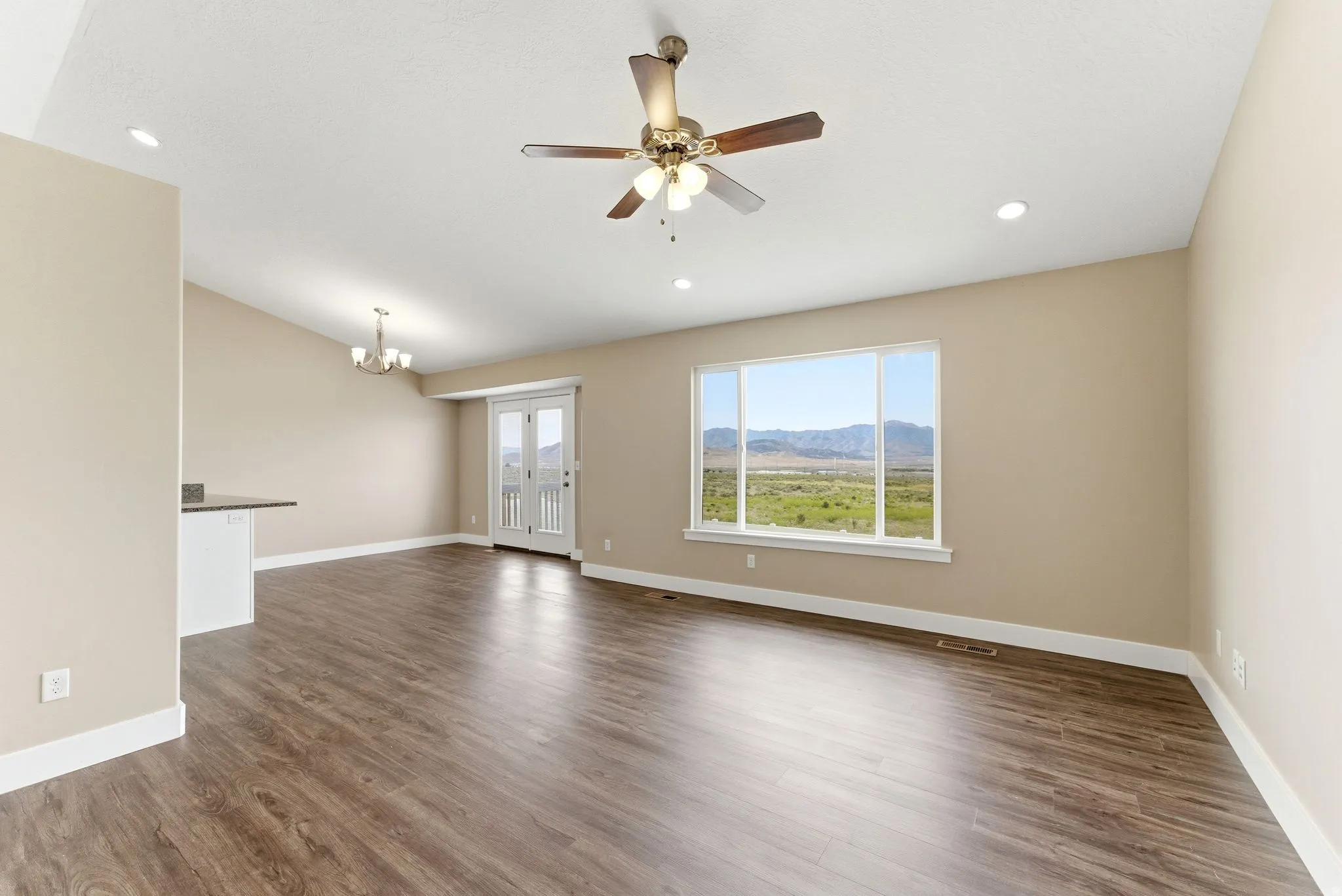 Spacious living area featuring wood-finish flooring, recessed lighting, and a ceiling fan