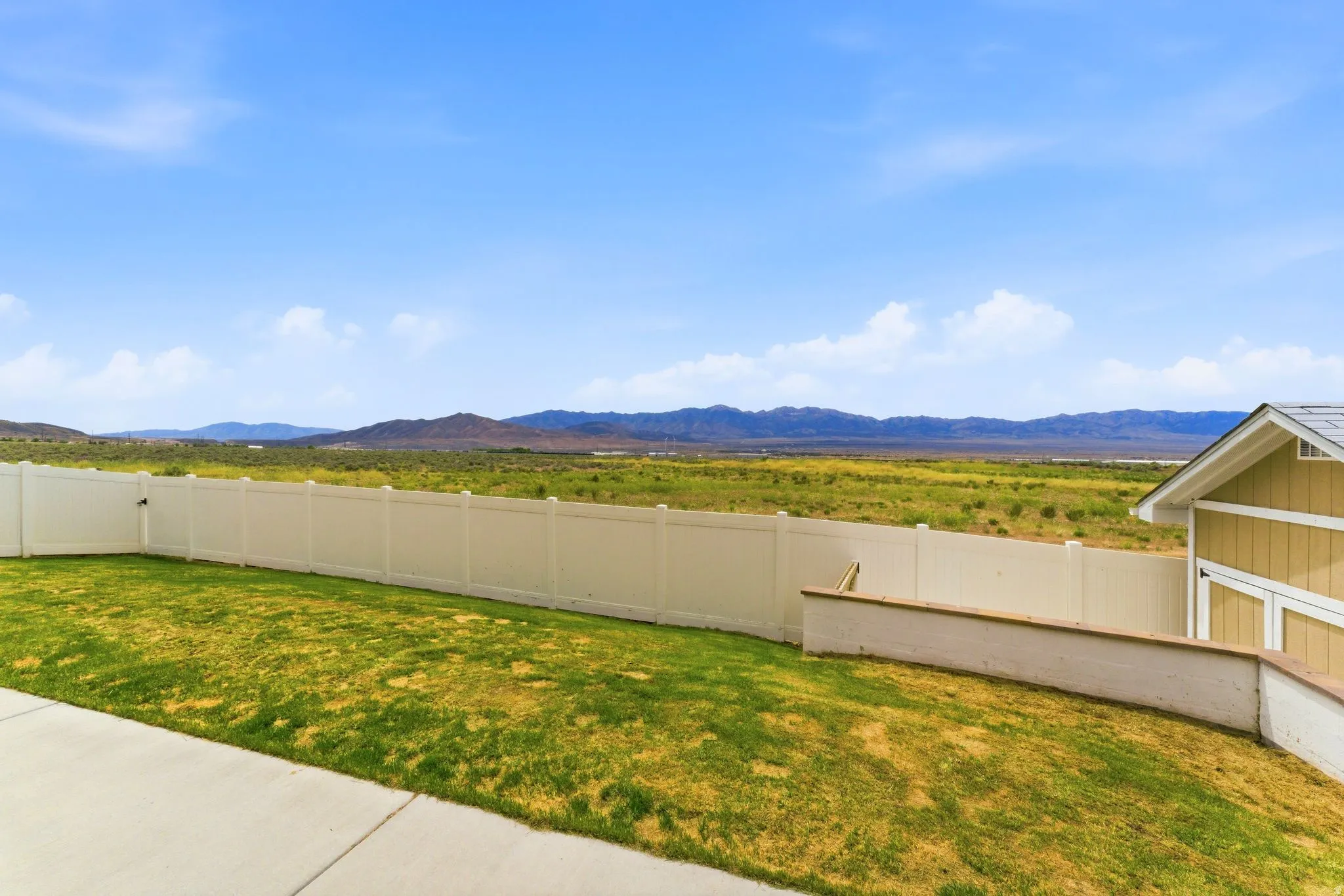 Expansive backyard featuring a manicured lawn, a concrete patio, and a privacy fence