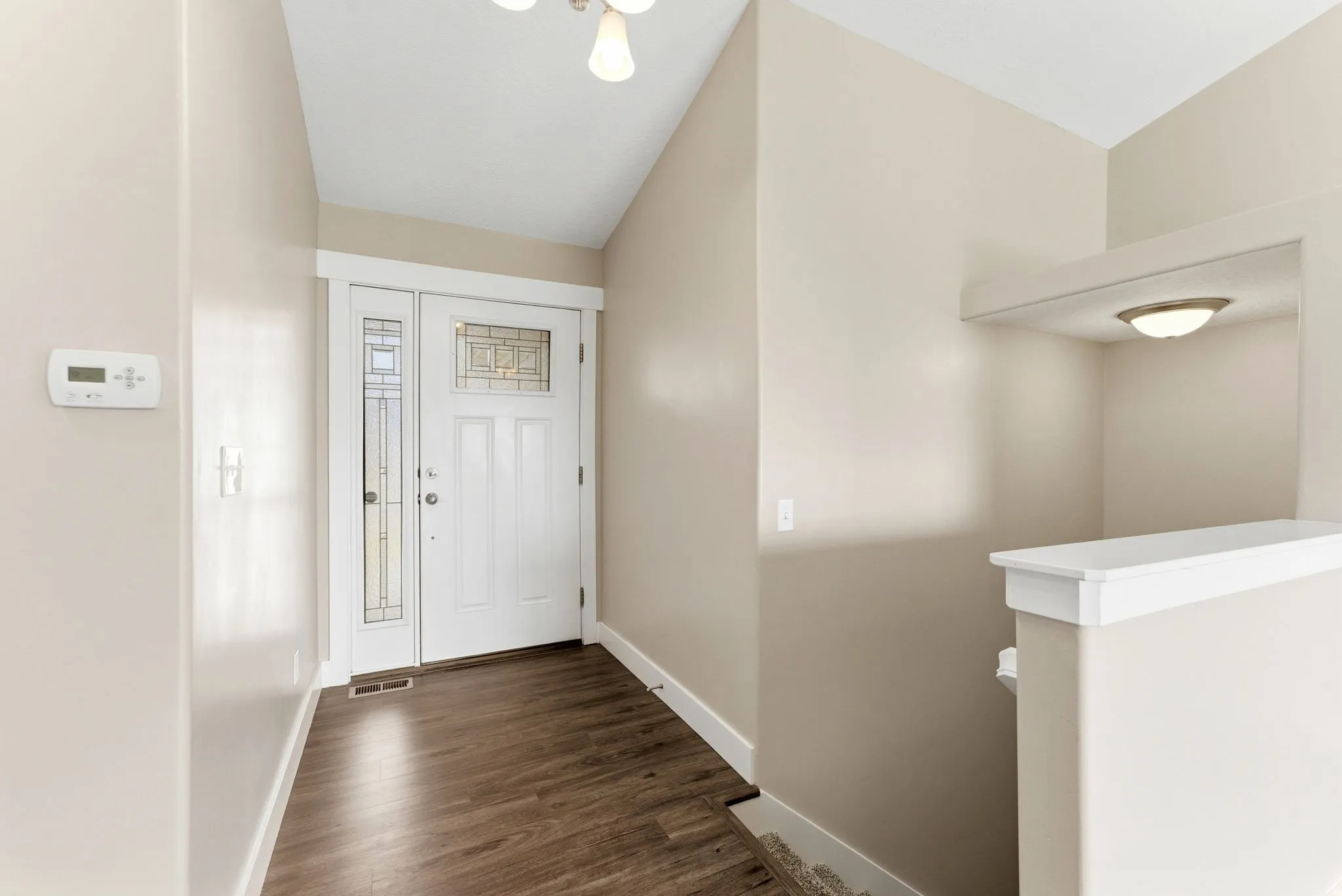 Entryway featuring wood-finish flooring and a white front door with decorative glass inserts