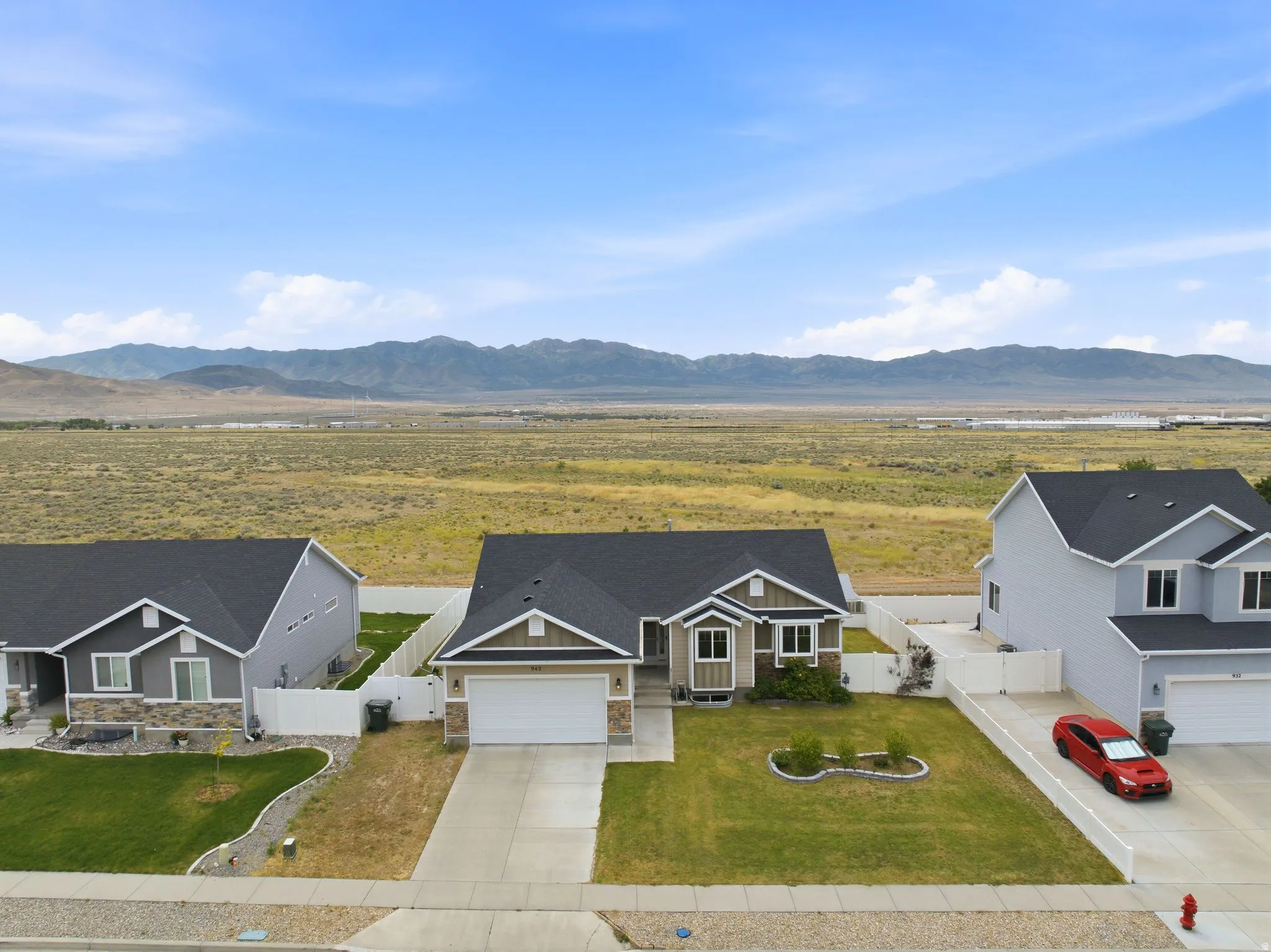 Contemporary single-story residence featuring a two-car garage, stone and siding exterior accents, and a landscaped front yard