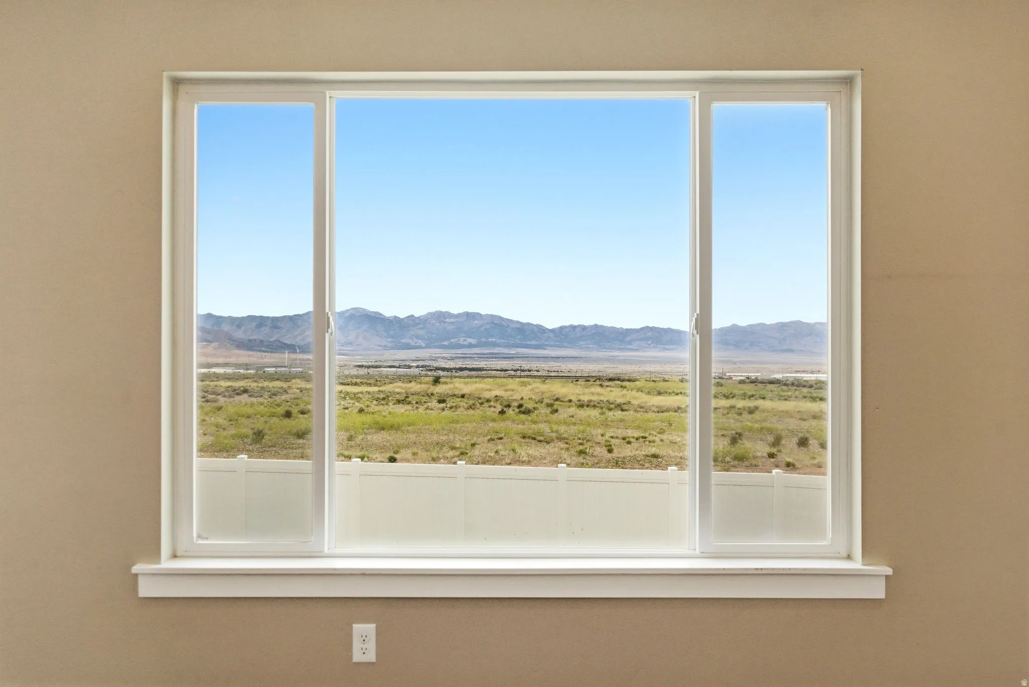 Sliding glass window offering expansive desert and mountain scenery