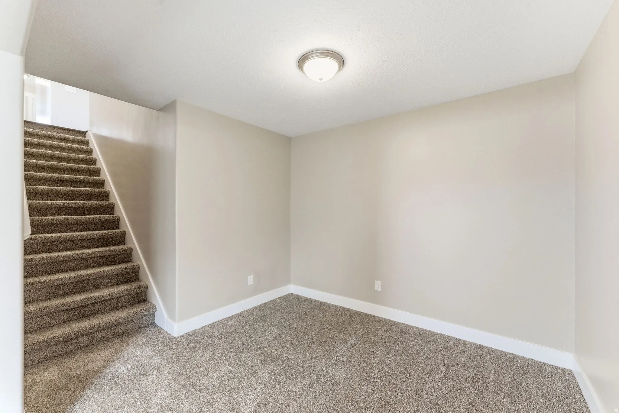 Carpeted staircase and flooring with neutral wall tones