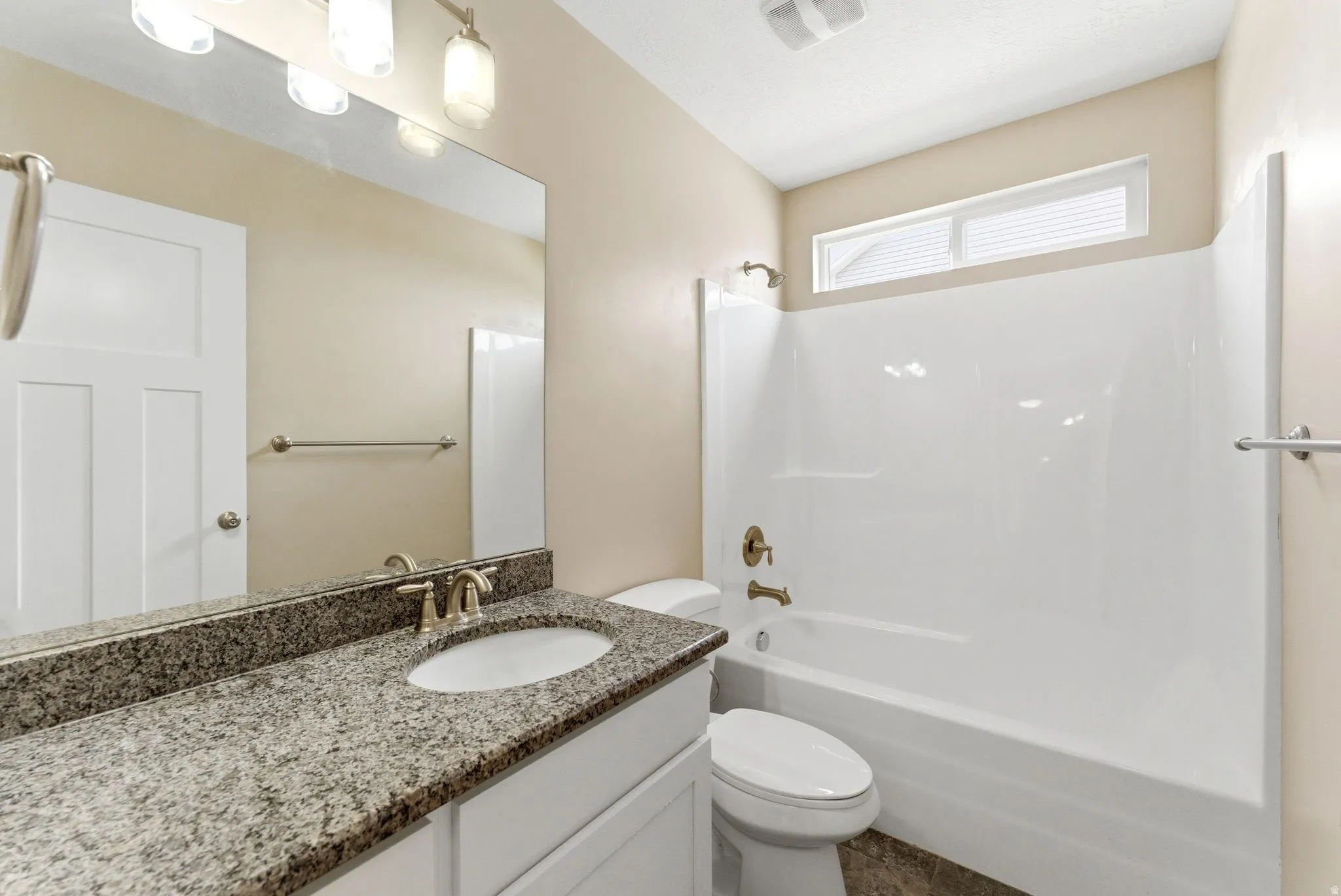 Bathroom featuring a white vanity with granite-style countertop, undermount sink, and brushed nickel faucet
