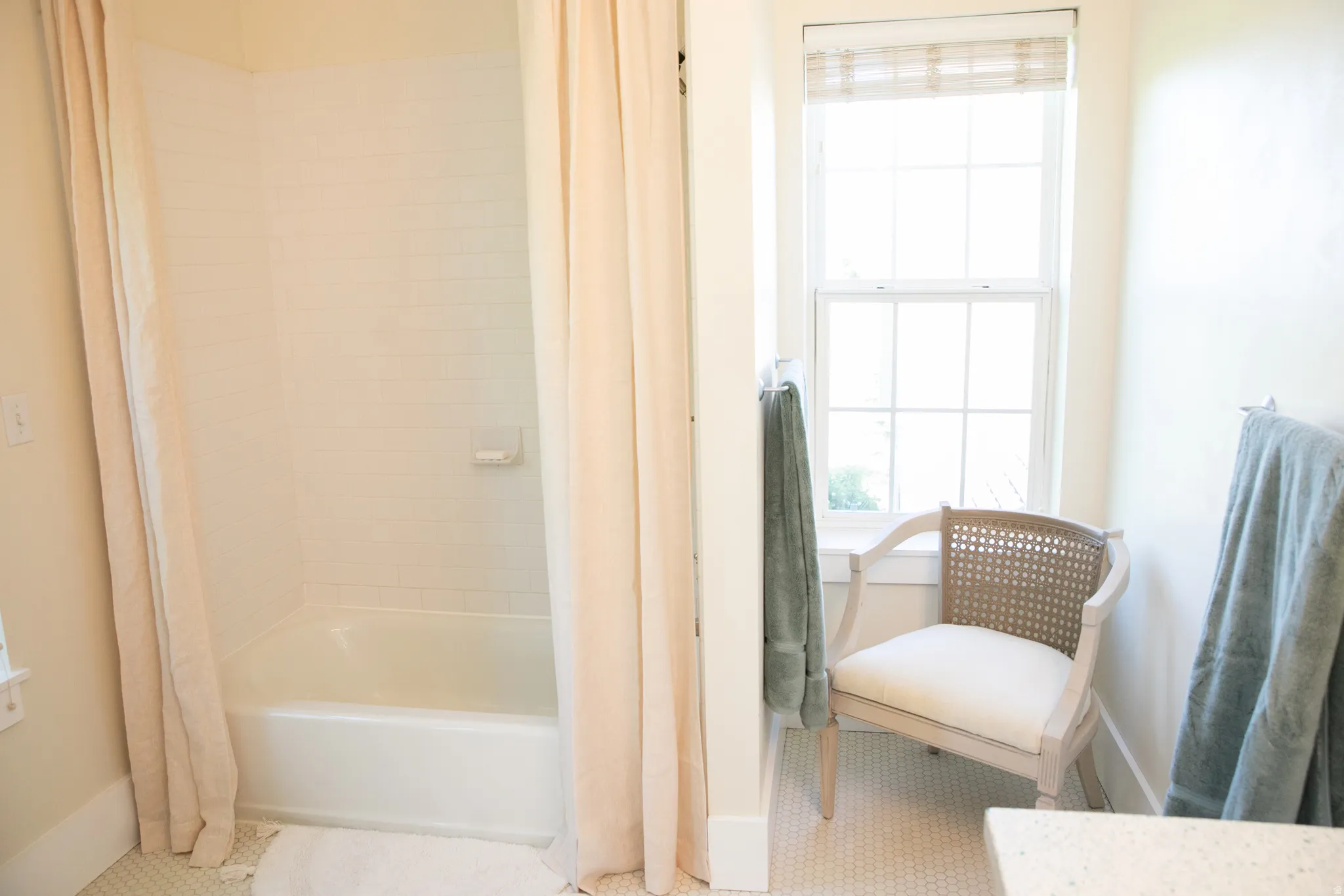 Bathroom featuring a white subway-tiled tub and shower combination