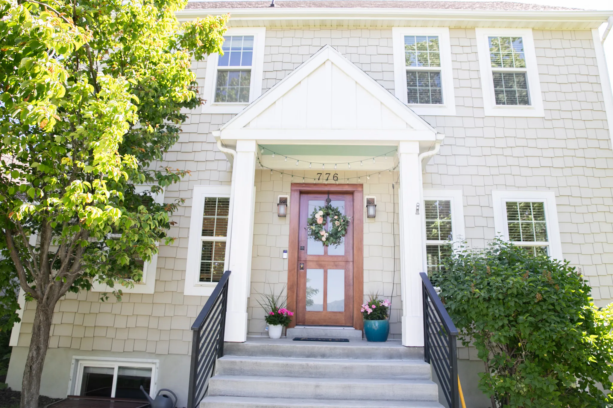 Front entry featuring a wood door with glass paneling, overhead lighting, and a prominent portico