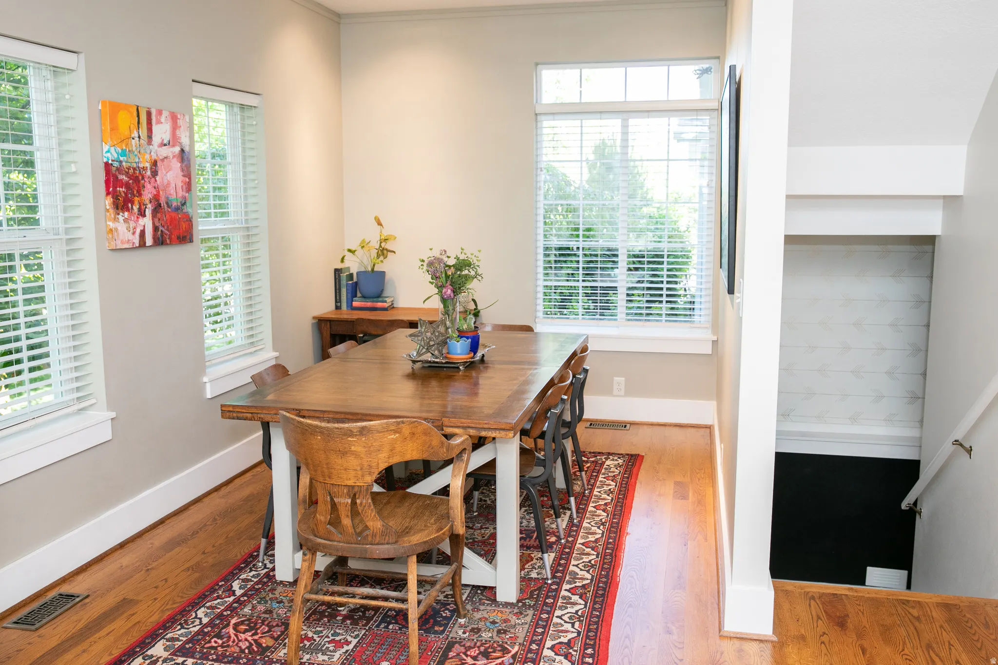 Dining area featuring hardwood flooring, multiple windows with blinds, and white trim