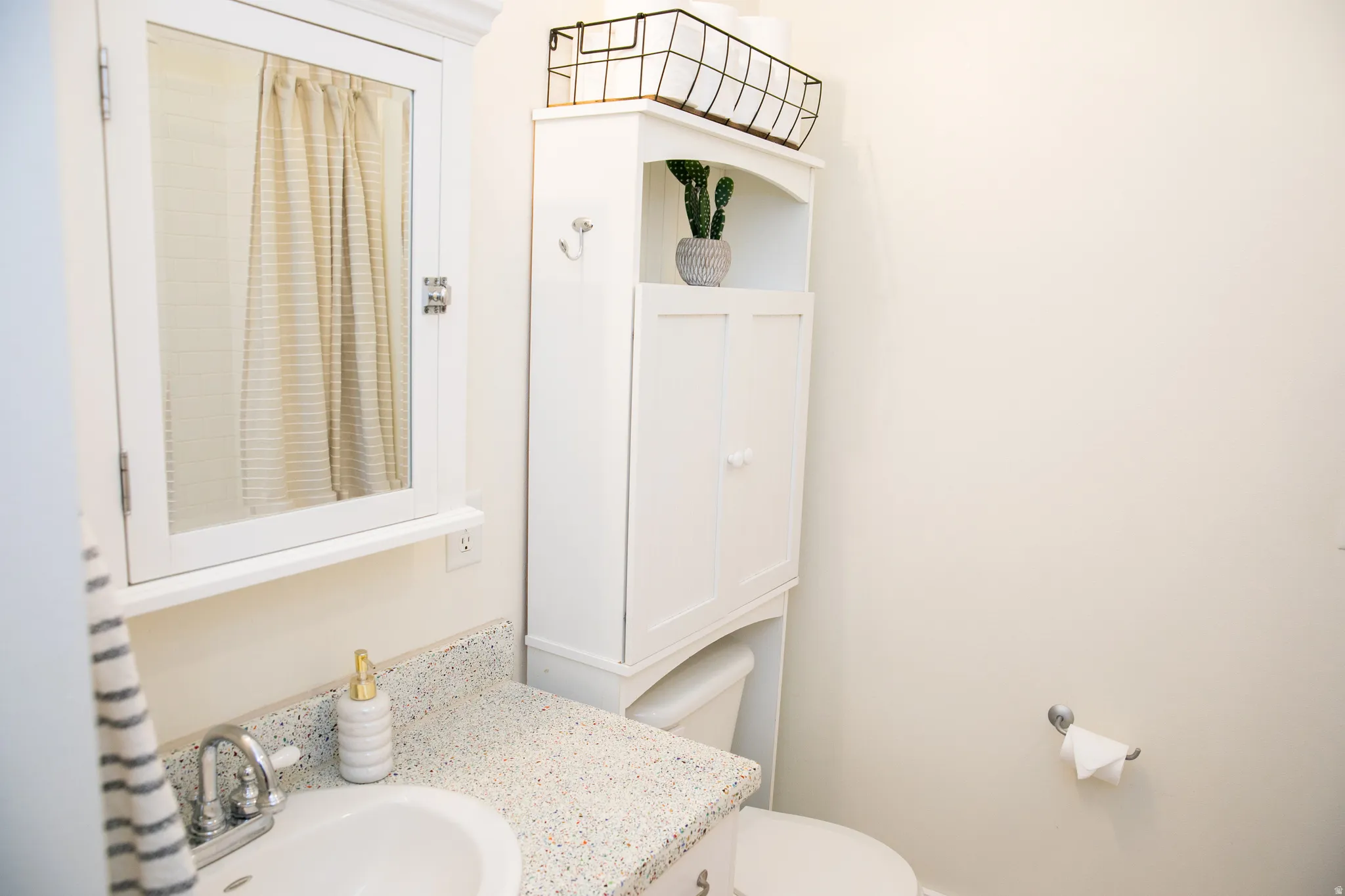 White vanity with an integrated sink and specked countertop