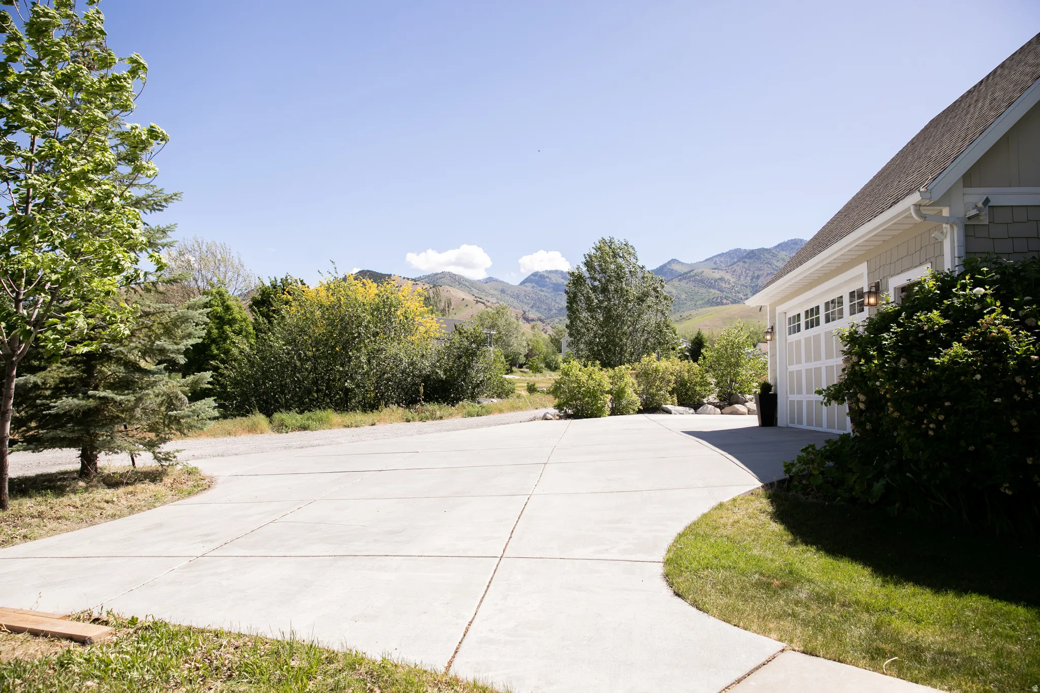 Concrete driveway providing access to a two-car garage with overhead lighting