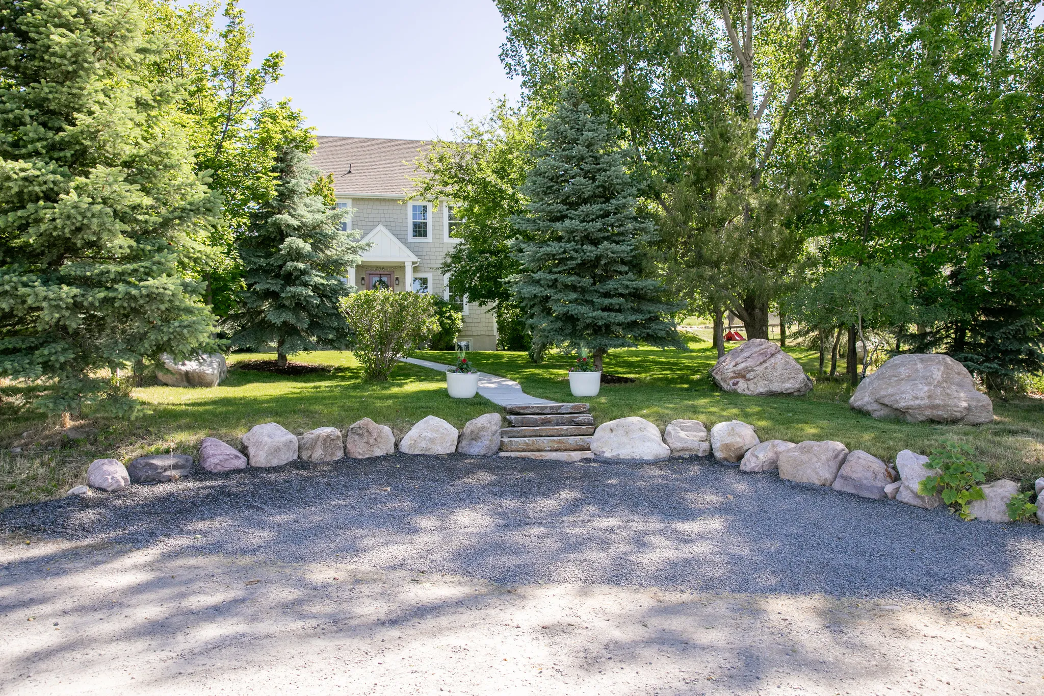 Gravel driveway bordered by natural stone landscaping