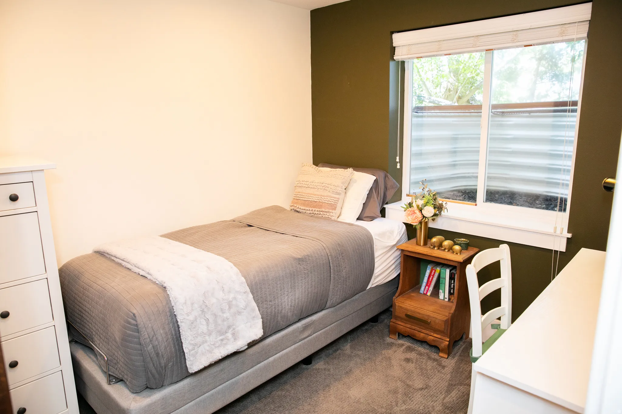 Carpeted room with a window featuring horizontal blinds