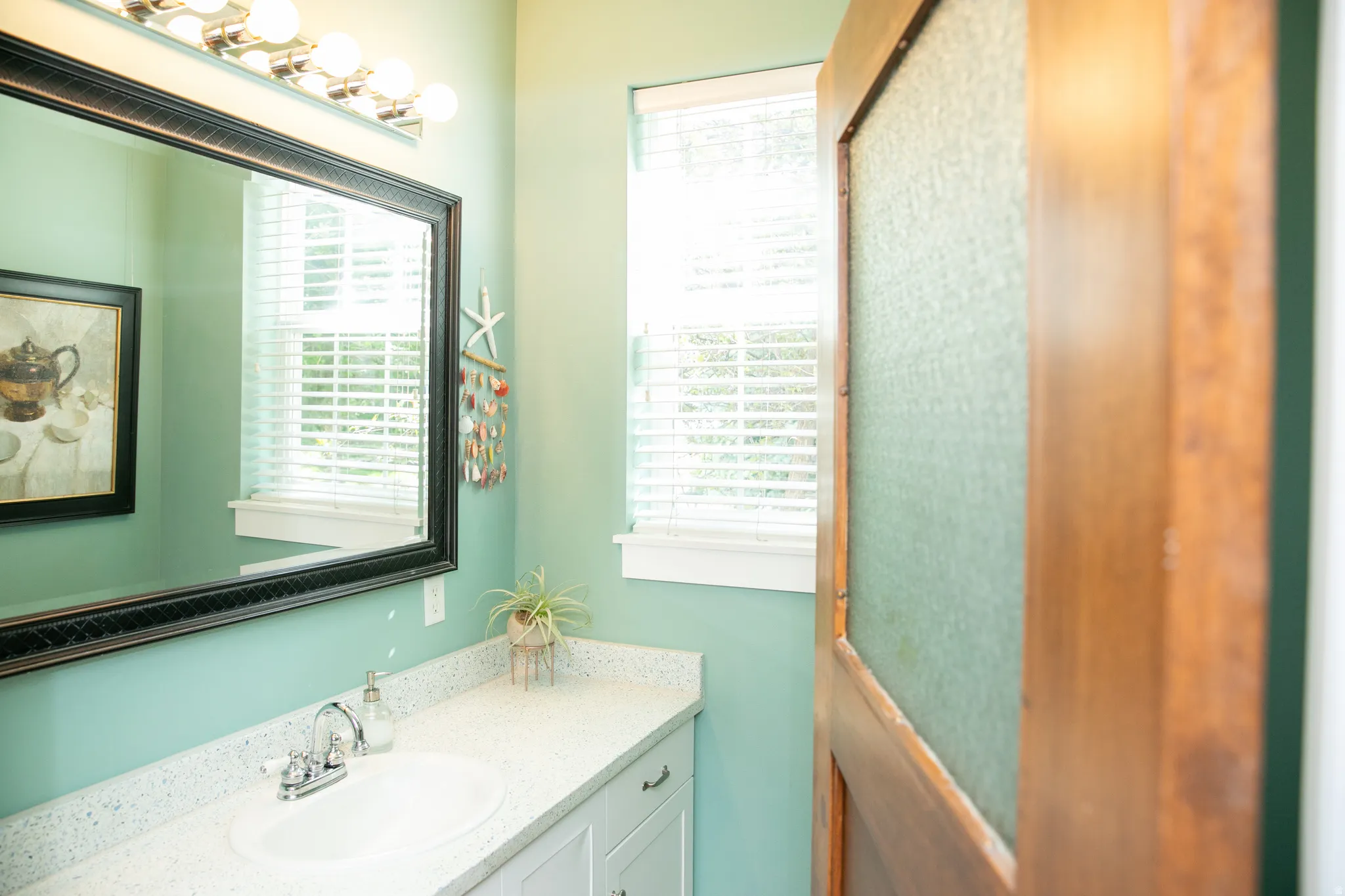 Bathroom vanity featuring a speckled countertop, undermount sink, and chrome faucet