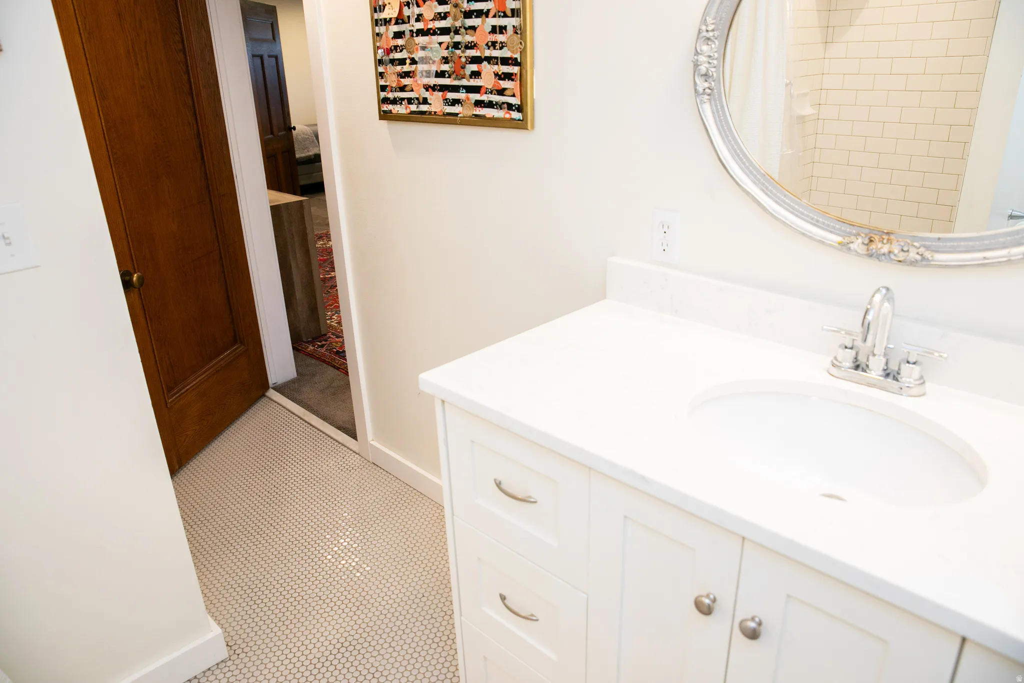 White vanity with an integrated sink, polished chrome faucet, and white countertop