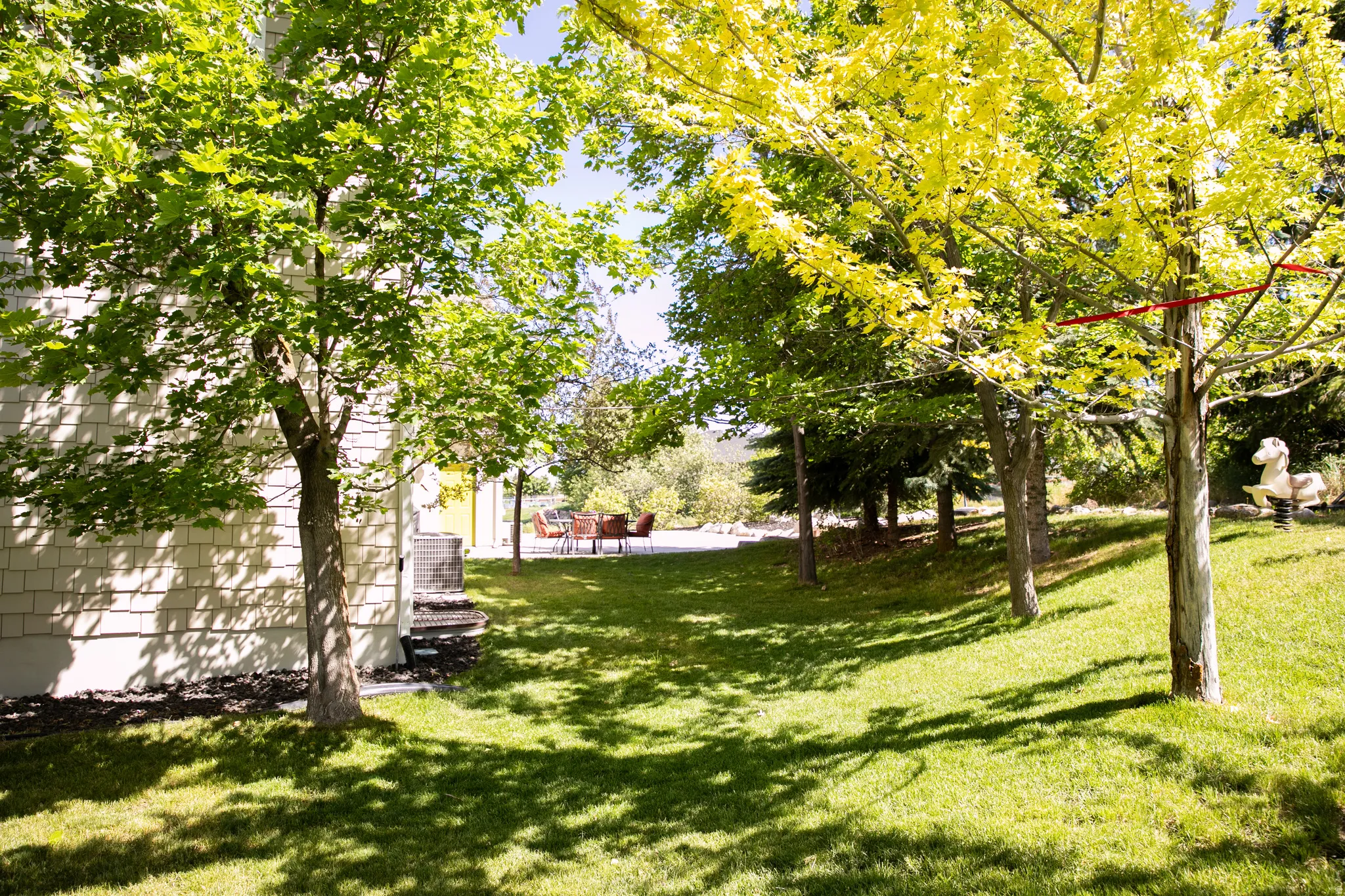 Expansive lawn featuring mature trees providing shade