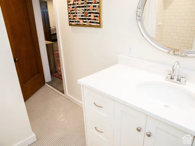 White vanity with an integrated sink, polished chrome faucet, and white countertop
