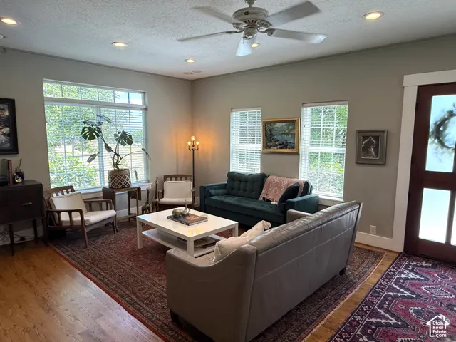 Spacious living area featuring wood-finish flooring, recessed lighting, and a ceiling fan