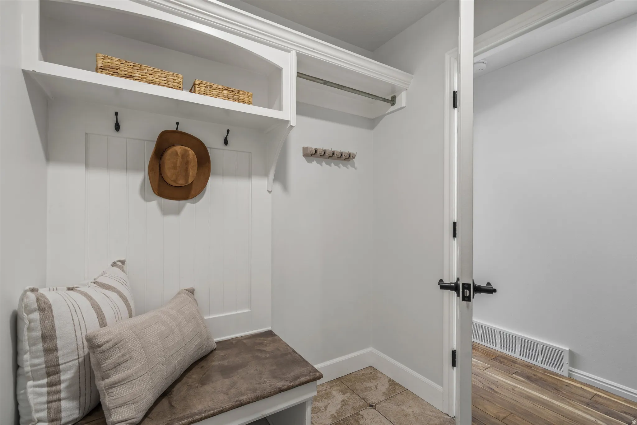 Laundry area Built-in mudroom bench with cushioned seating, overhead storage, and coat hooks