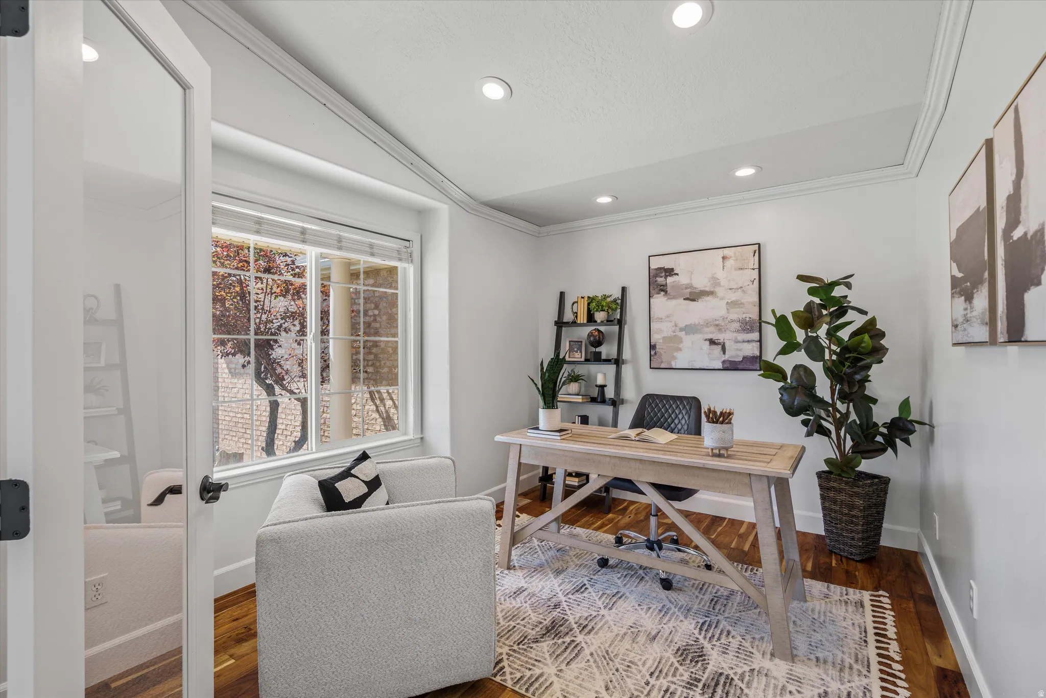 Bright room featuring a large window, recessed lighting, crown molding, and wood-finish flooring