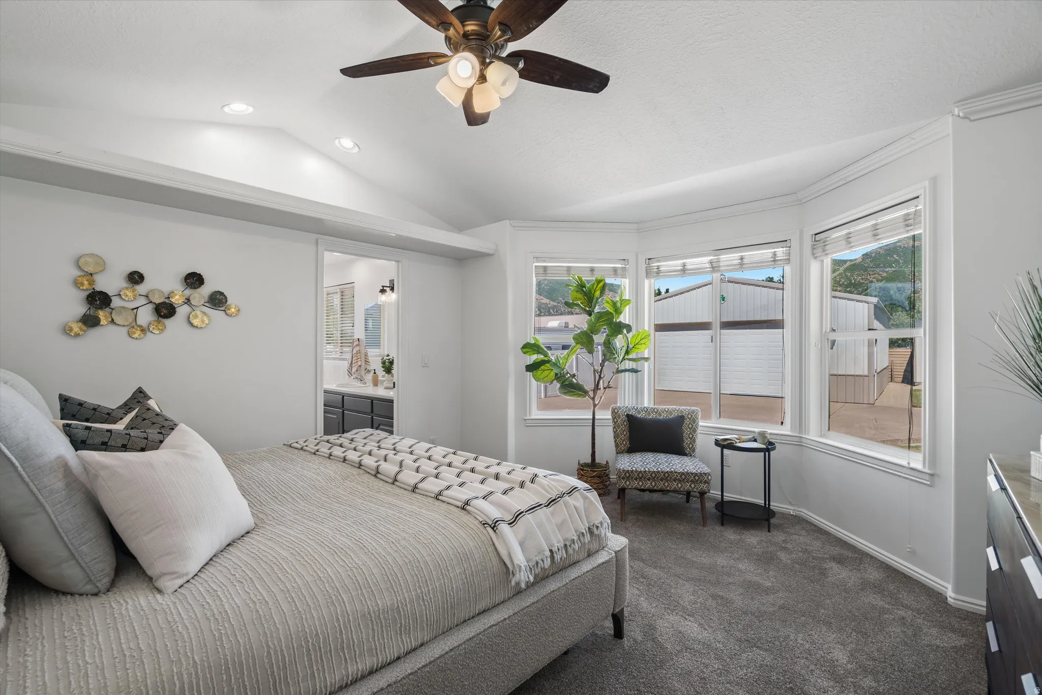 Spacious Primary bedroom featuring a vaulted ceiling with a ceiling fan, recessed lighting, and a prominent bay window
