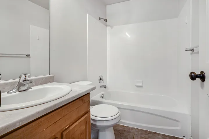 Vanity with a wood-finish cabinet, integrated sink, and chrome faucet