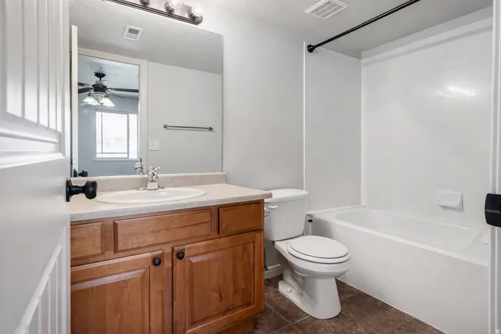 Vanity with wood-finish cabinetry, integrated sink, and laminate countertop