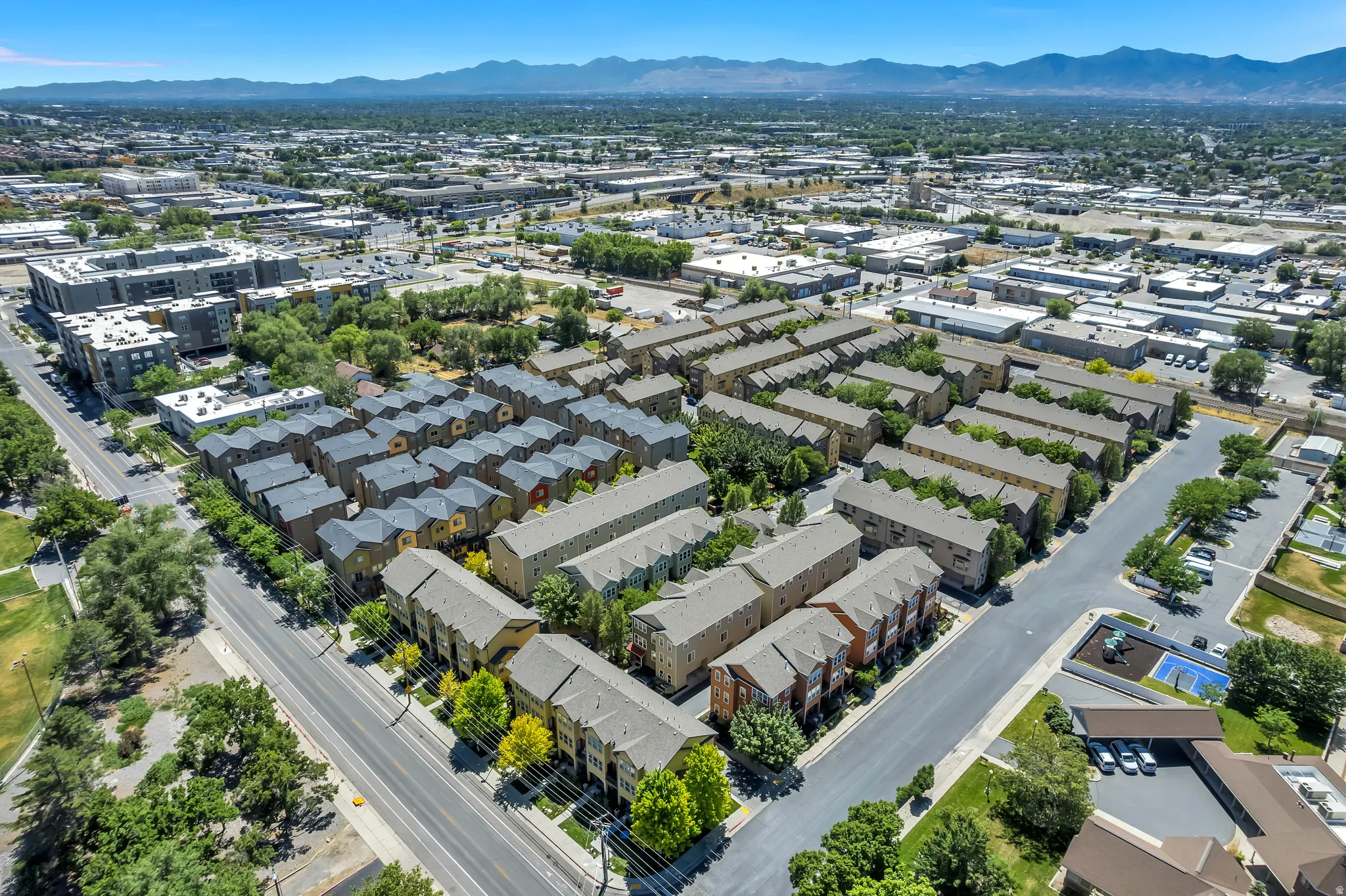 Aerial perspective showcasing a residential development with multiple rows of townhomes and apartment complexes