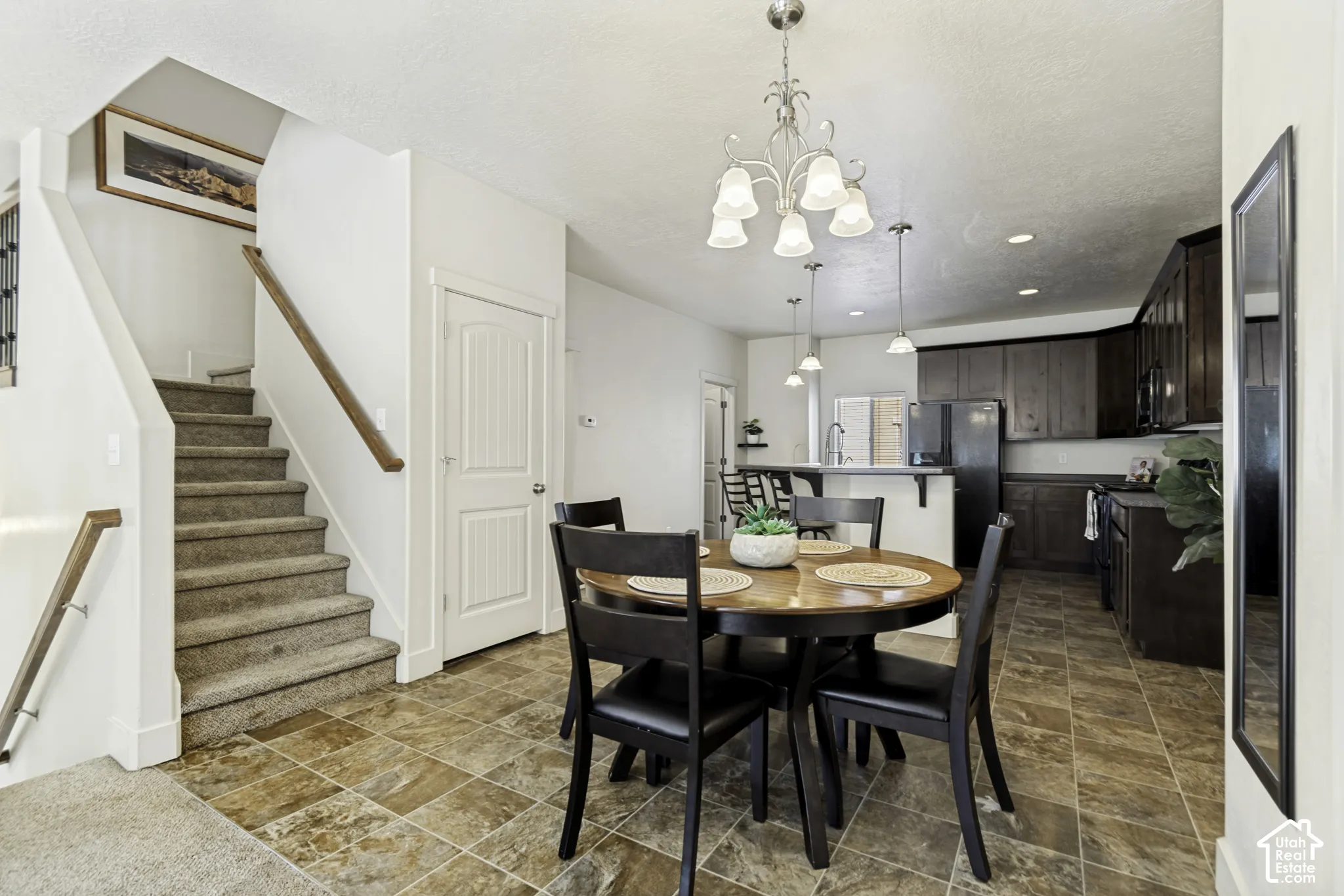 Open-concept dining and kitchen area featuring a prominent staircase