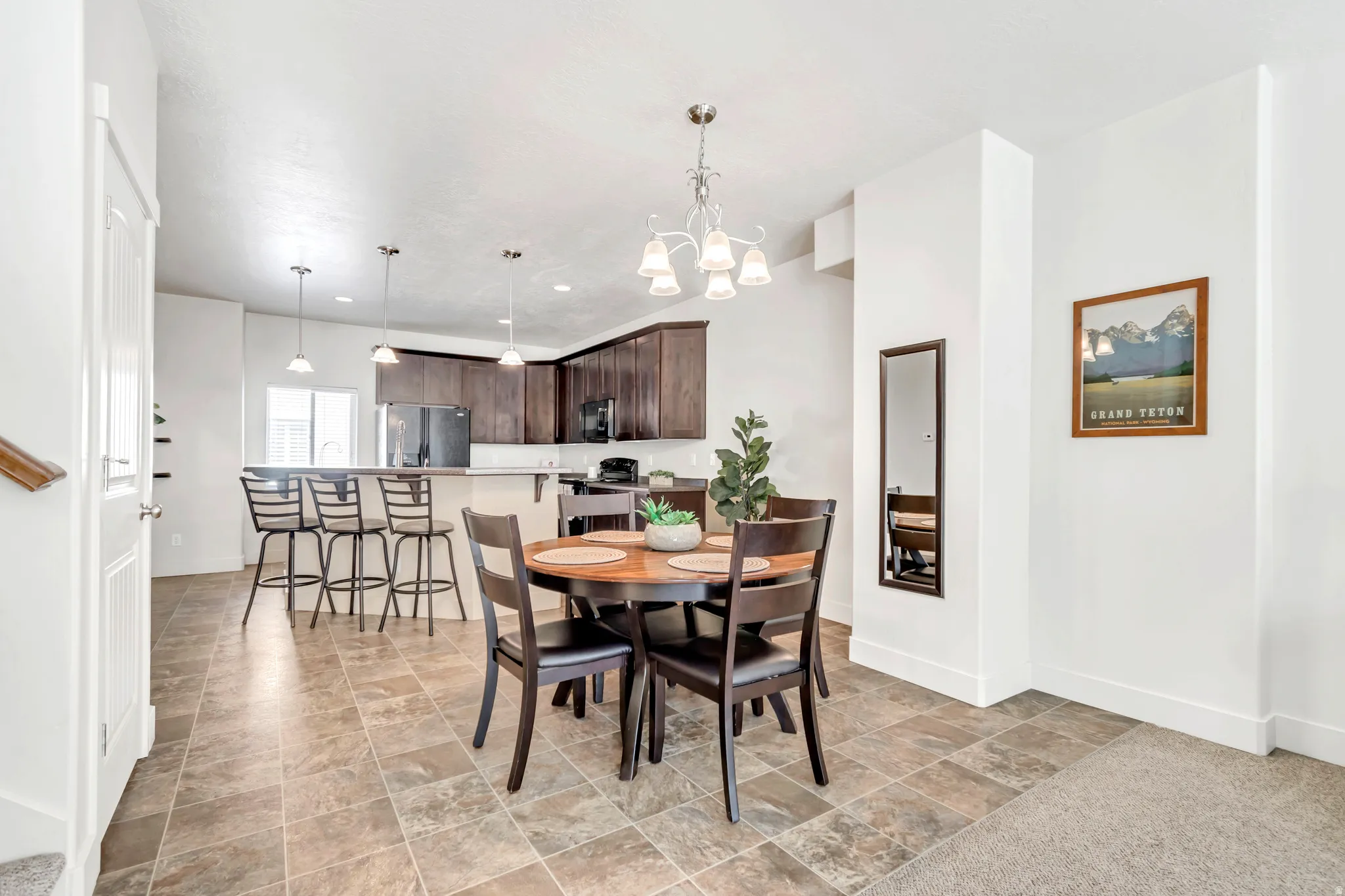 Open-concept living space with tile flooring throughout the dining area and kitchen