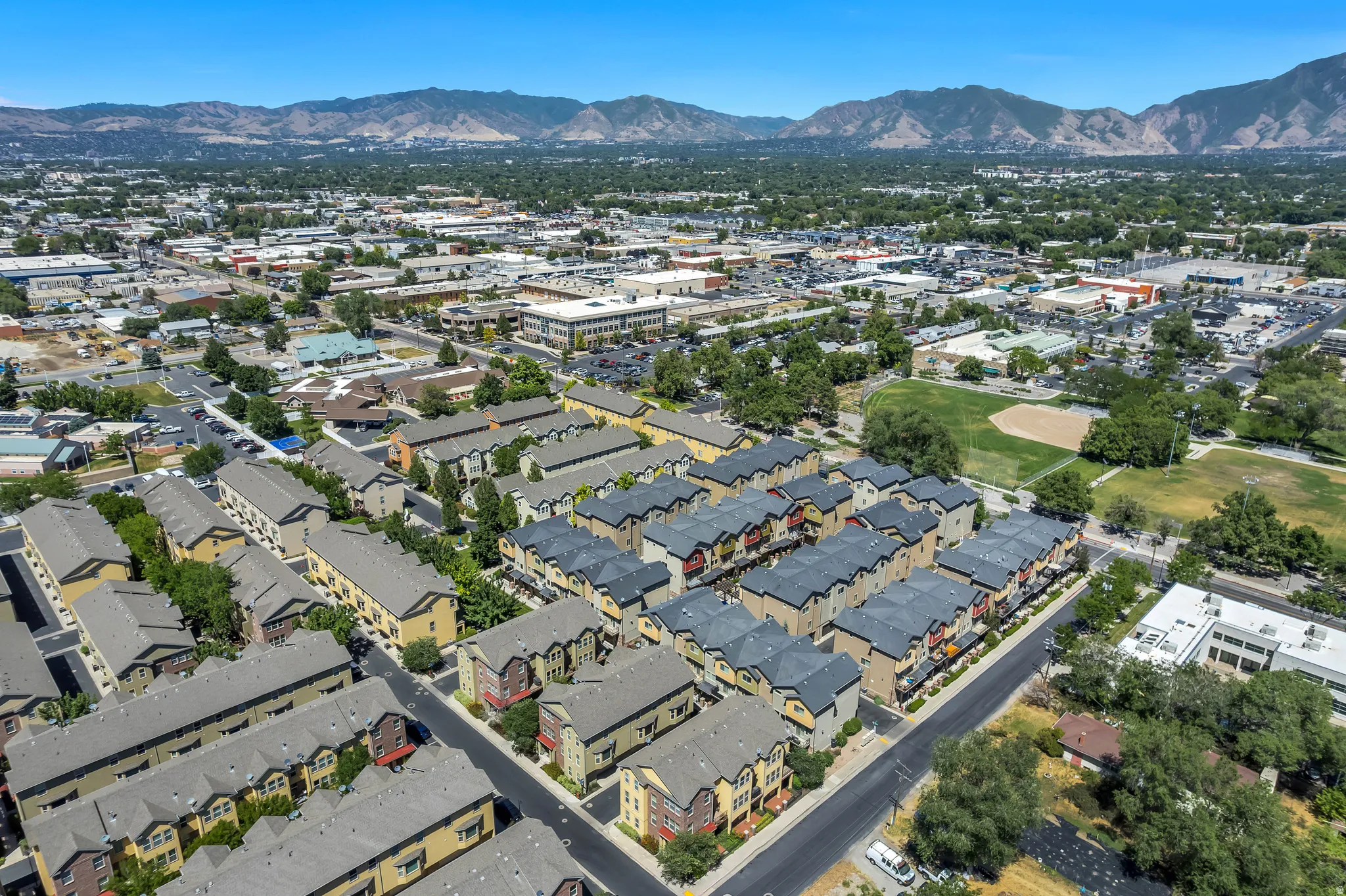 Community of multi-story townhomes with pitched roofs and varied exterior finishes