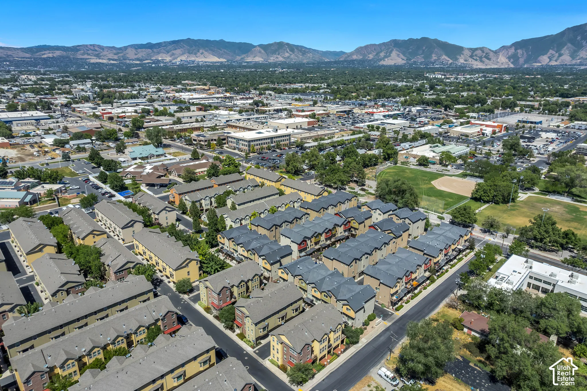 Community of multi-story townhomes with pitched roofs and varied exterior finishes