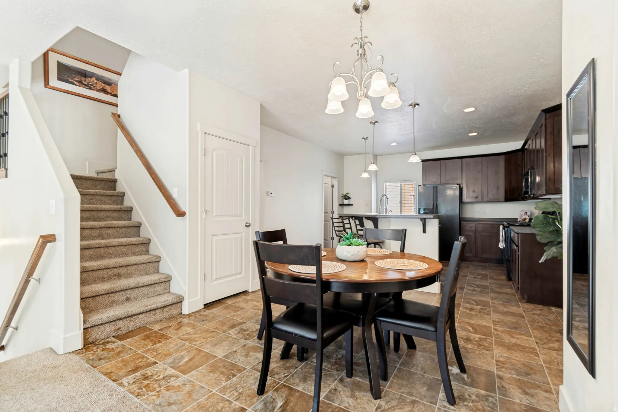 Open-concept dining and kitchen area featuring a prominent staircase