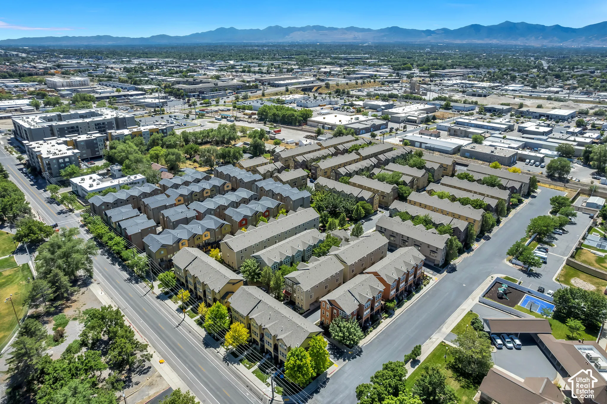 Aerial perspective showcasing a residential development with multiple rows of townhomes and apartment complexes