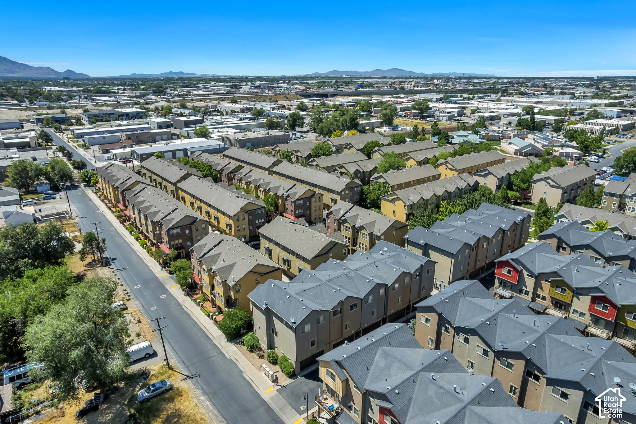 Contemporary multi-story townhomes featuring varied exterior finishes, individual balconies, and dark-toned roofing