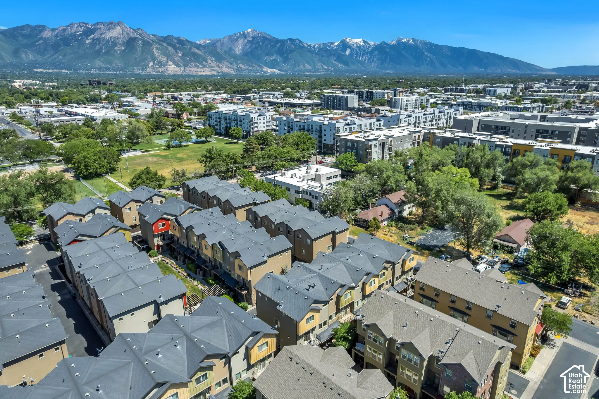 Aerial perspective showcasing residential structures with snow-capped mountains in the background