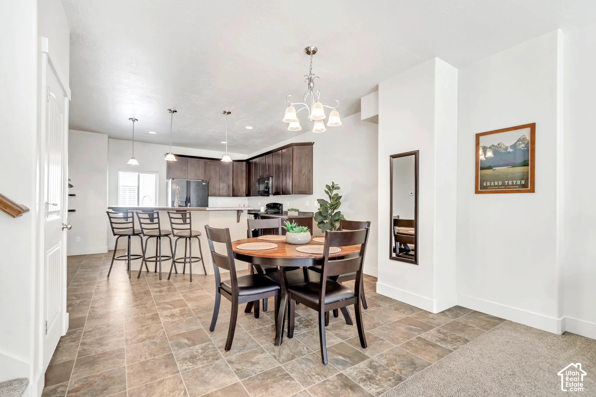 Open-concept living space with tile flooring throughout the dining area and kitchen