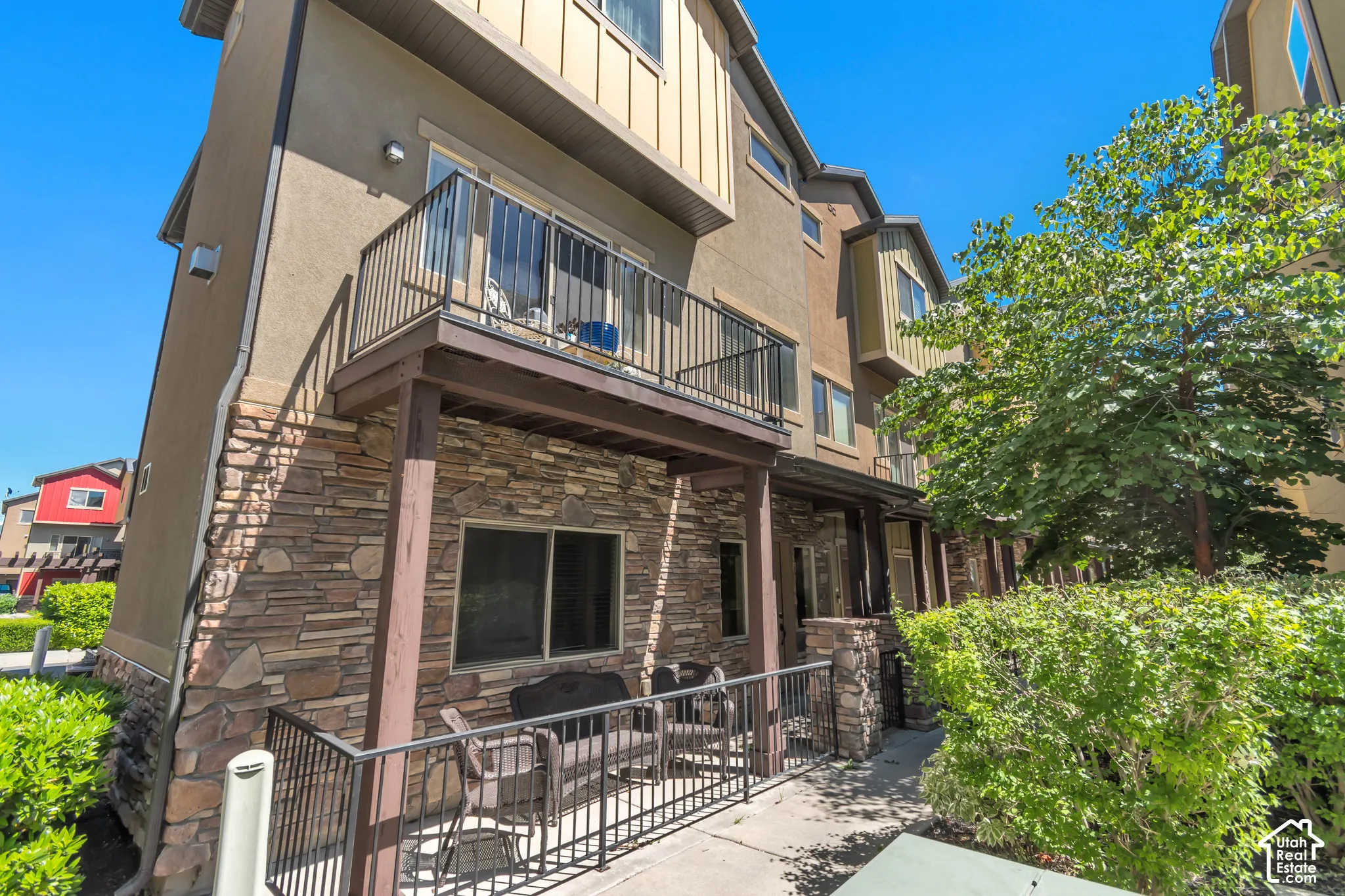 Multi-story townhome exterior featuring stone veneer and stucco siding
