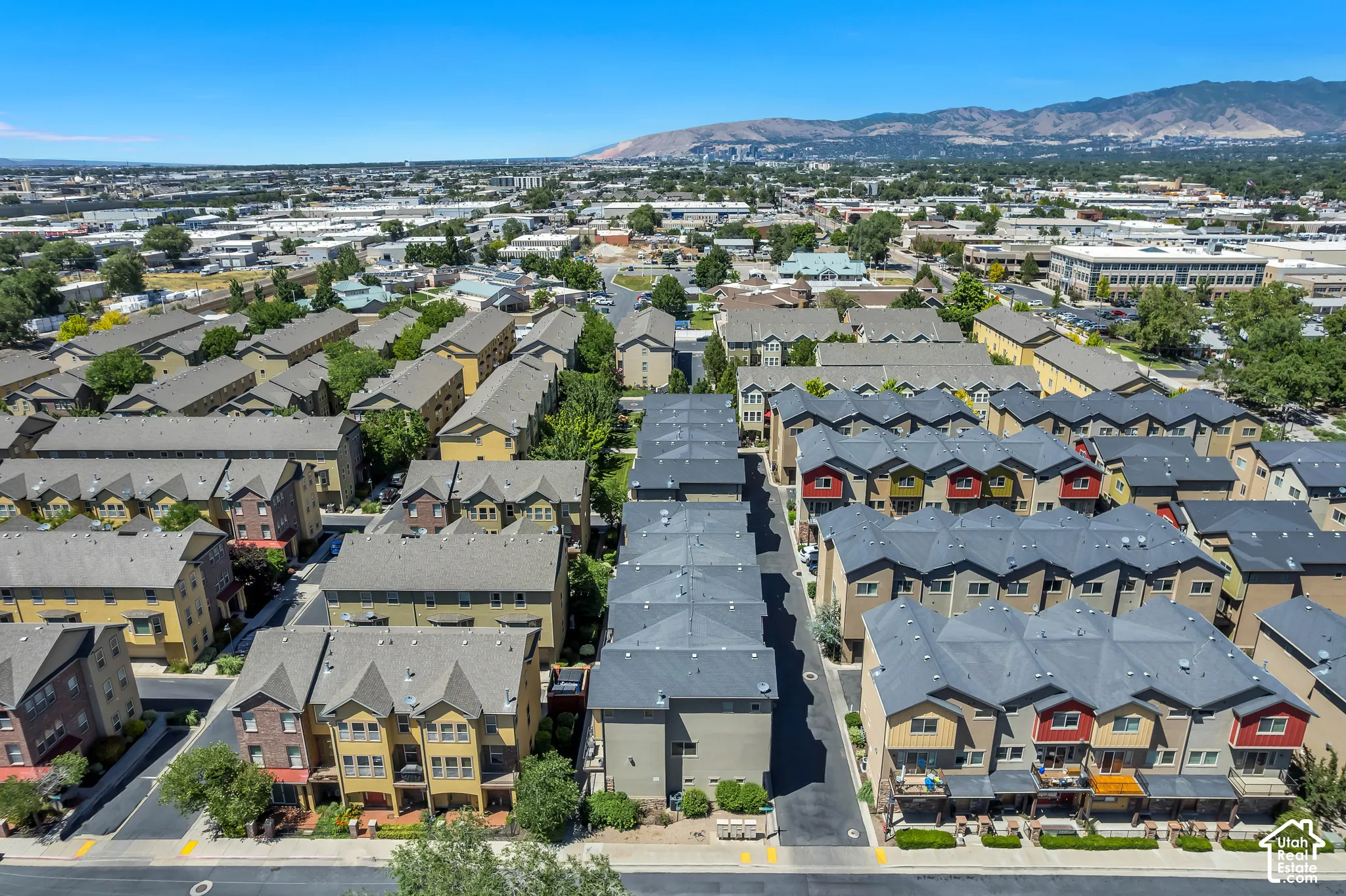 Aerial perspective showcasing multiple rows of multi-story townhomes with distinct gabled and hip roofs