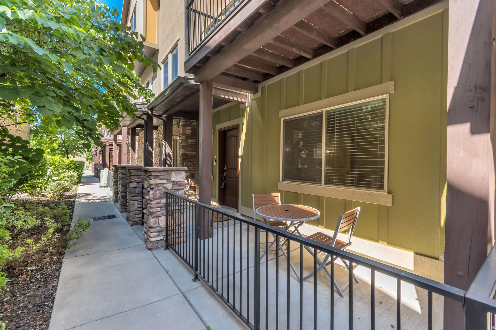 Private patio area featuring a metal railing and a paneled exterior wall