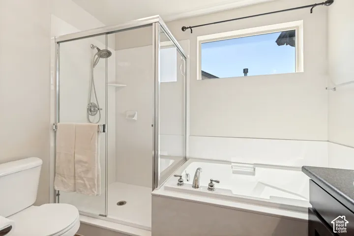 Bathroom featuring a glass-enclosed shower, a built-in soaking tub with chrome fixtures, a privacy window, and a dark-finished vanity with a stone-finish countertop