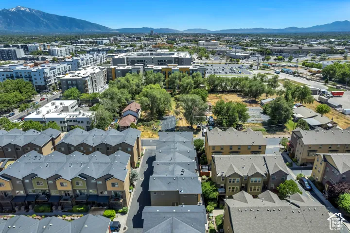 Townhome development featuring contemporary architecture with multi-story buildings, dark gray shingled roofs, and varied exterior siding colors